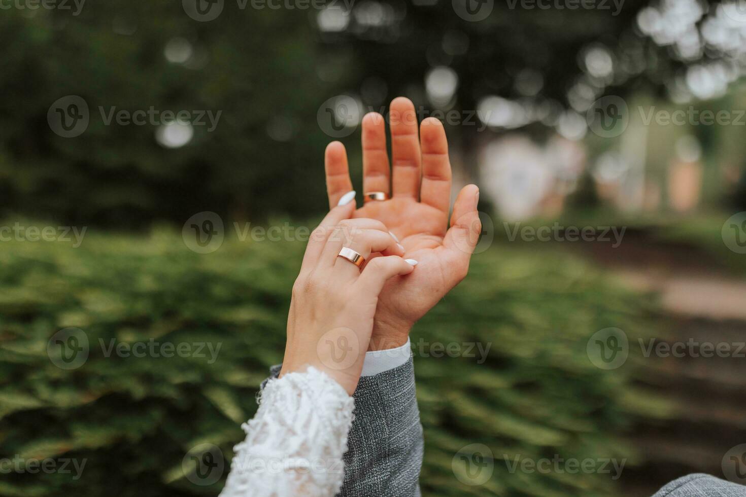 uma lindo luxo casamento. fechar-se do noiva e do noivo mãos. a noivo detém a da noiva mão. □ Gentil toques do dedos. Casamento anel foto