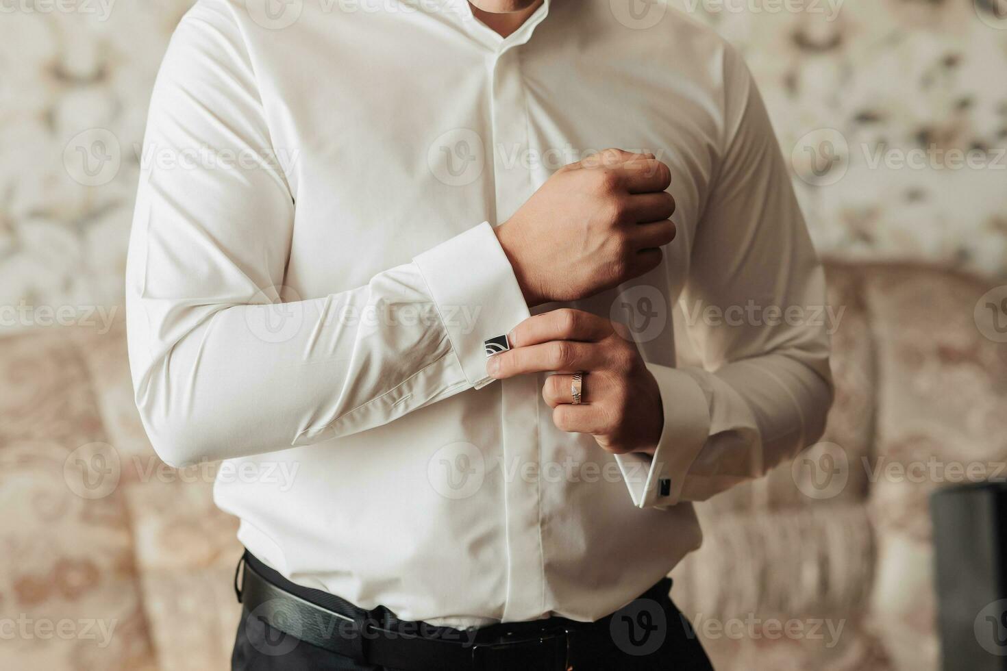 foto detalhes. uma homem aperta uma botão em a manga do uma branco camisa. frente visualizar. luz do dia. moda e estilo. negócios. masculino estilo. lindo mãos