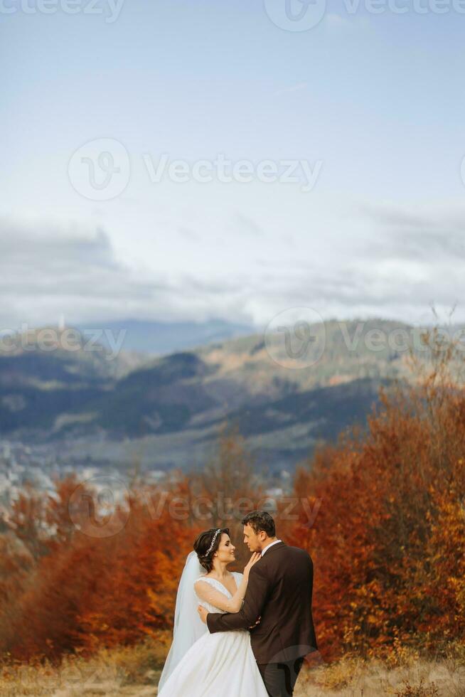 amoroso casal dentro a montanhas. casamentos dentro a montanhas. costas Visão do a recém-casado casal em pé em a montanhas e desfrutando a panorama. foto
