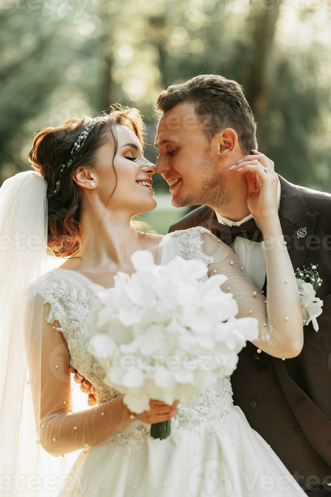 surpreendente sorridente Casamento casal. uma lindo noiva e uma à moda noivo. beijo do a noiva e noivo foto