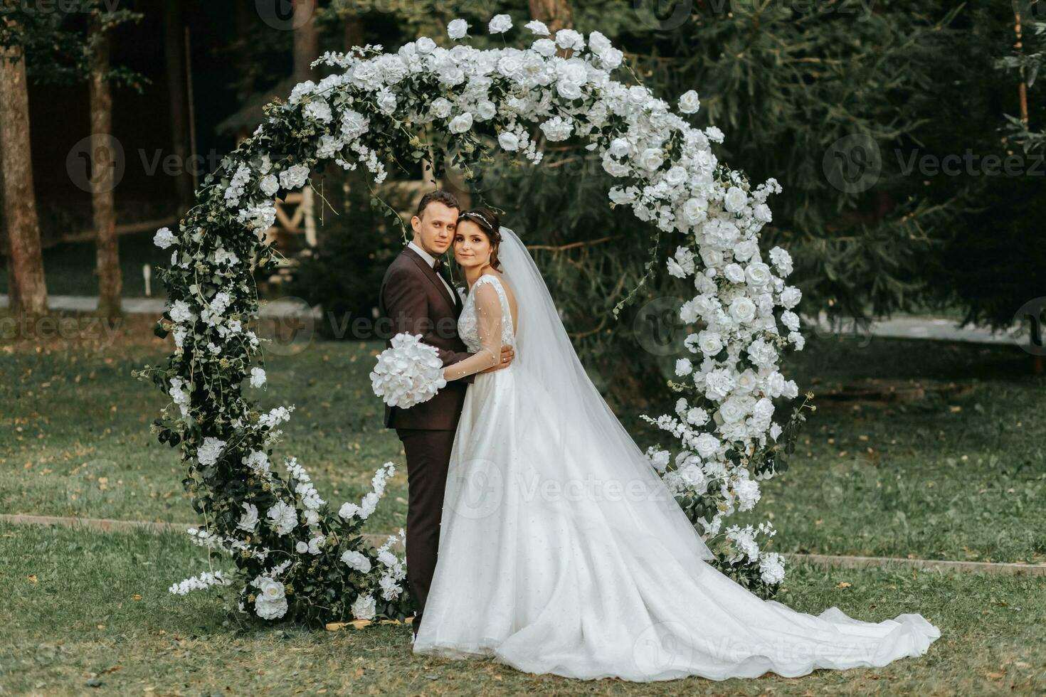 feliz noiva e noivo depois de Casamento cerimônia. volta cerimonial arco. grandes branco vestir do a noiva foto