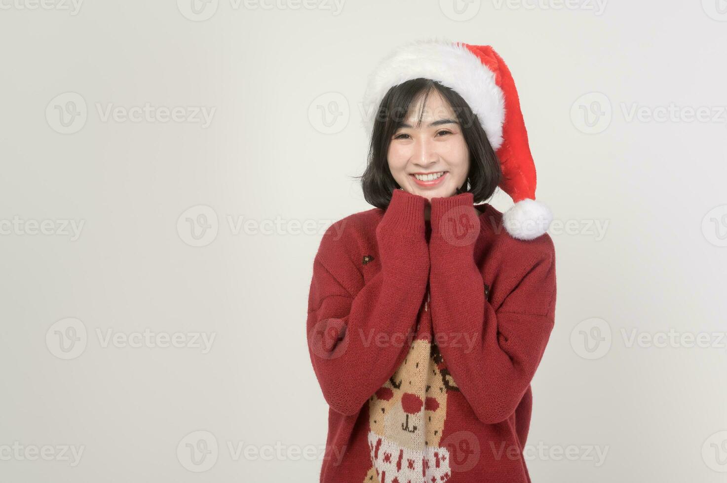 jovem feliz mulher dentro santa claus chapéu vestindo vermelho suéter sobre branco fundo, Natal conceito foto