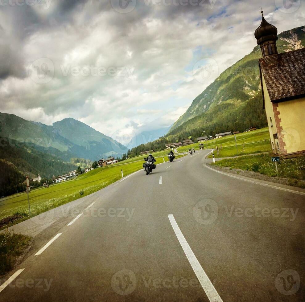 motociclista raça através montanhoso Vila foto