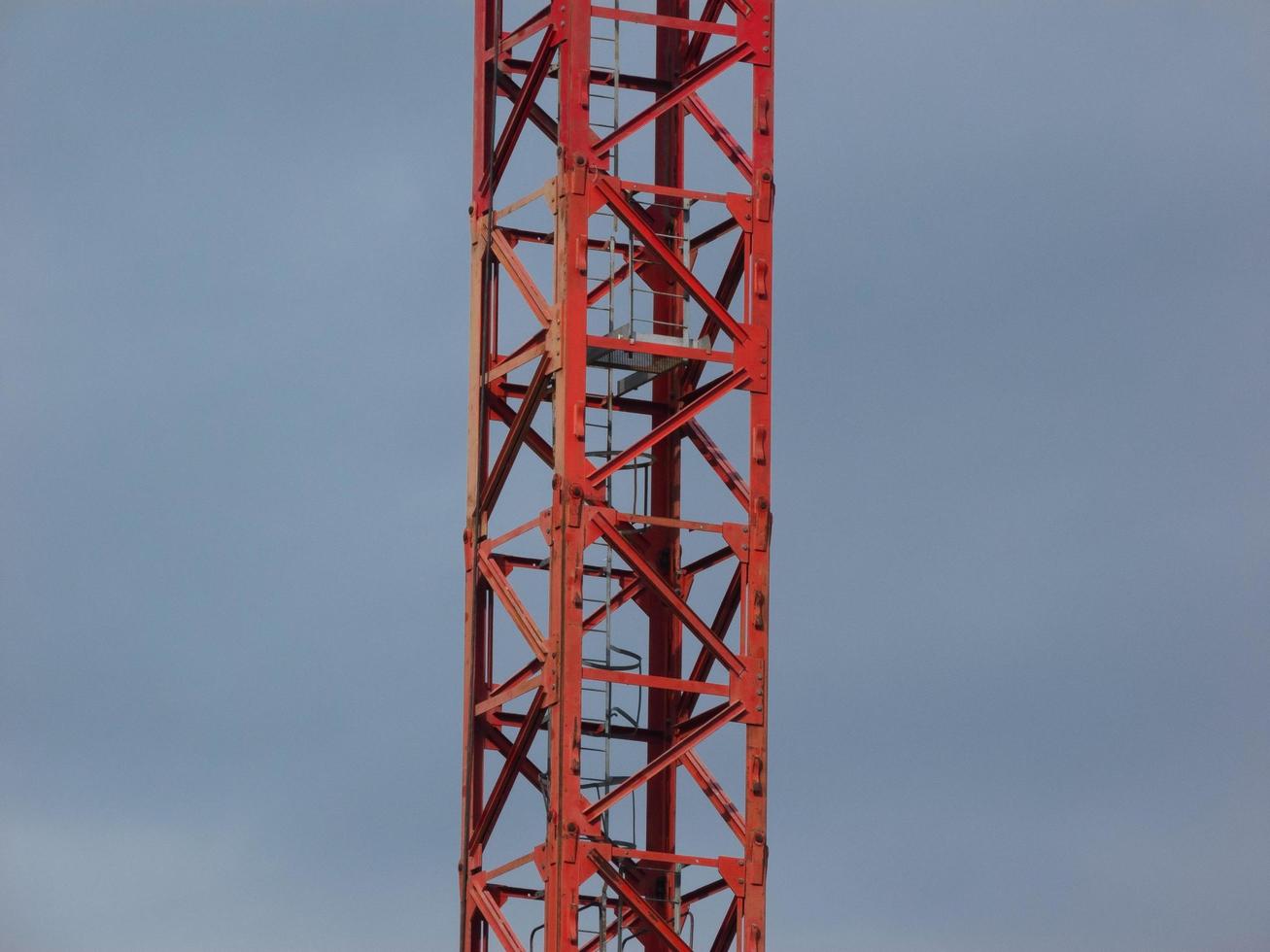 viga principal de um guindaste de torre contra fundo de céu nublado foto