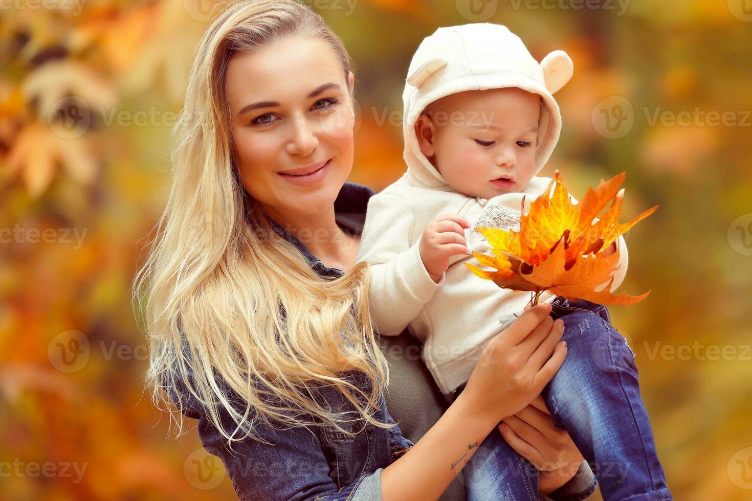 feliz mãe com bebê dentro outono parque foto