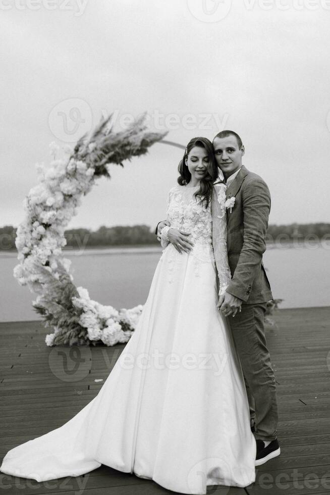 a primeiro Casamento dança do a noiva e noivo em a cais perto a rio foto