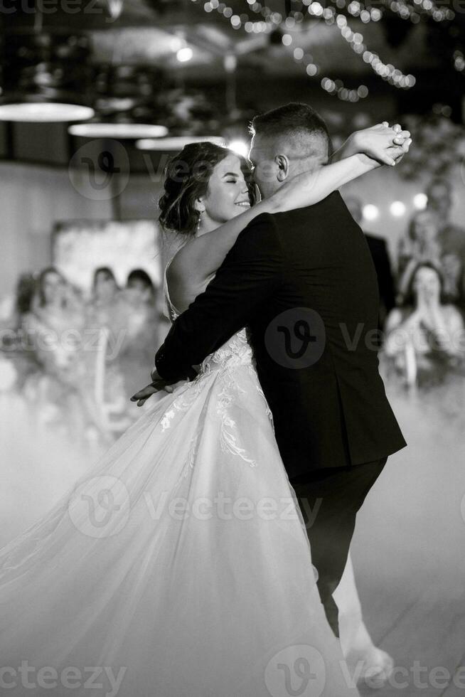 a primeiro dança do a noiva e noivo dentro uma restaurante foto