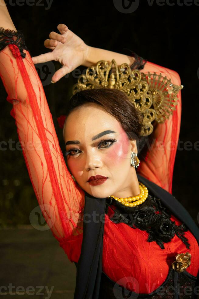 uma balinesa mulher desgasta pesado Maquiagem com rosado vermelho lábios e afiado cabelo quando posando foto