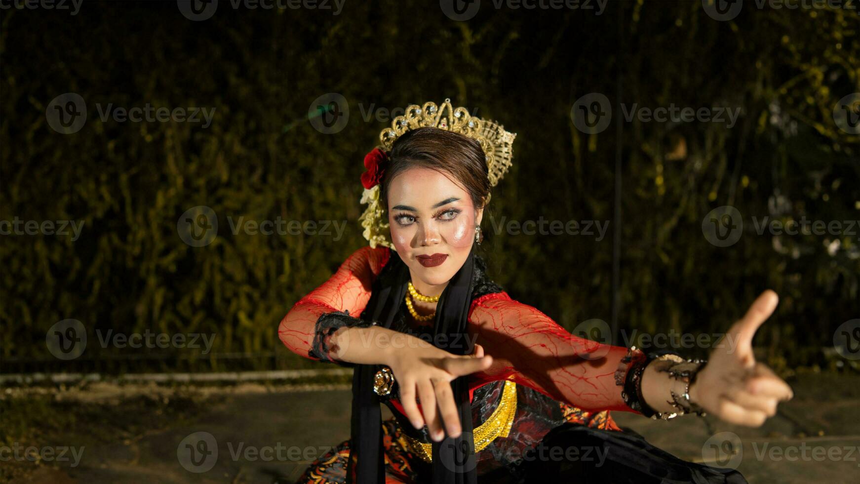 uma fêmea dançarino dentro uma vermelho vestir dançou em estágio, refletindo a beleza do dela movimentos e adicionando para a charme do dela desempenho foto