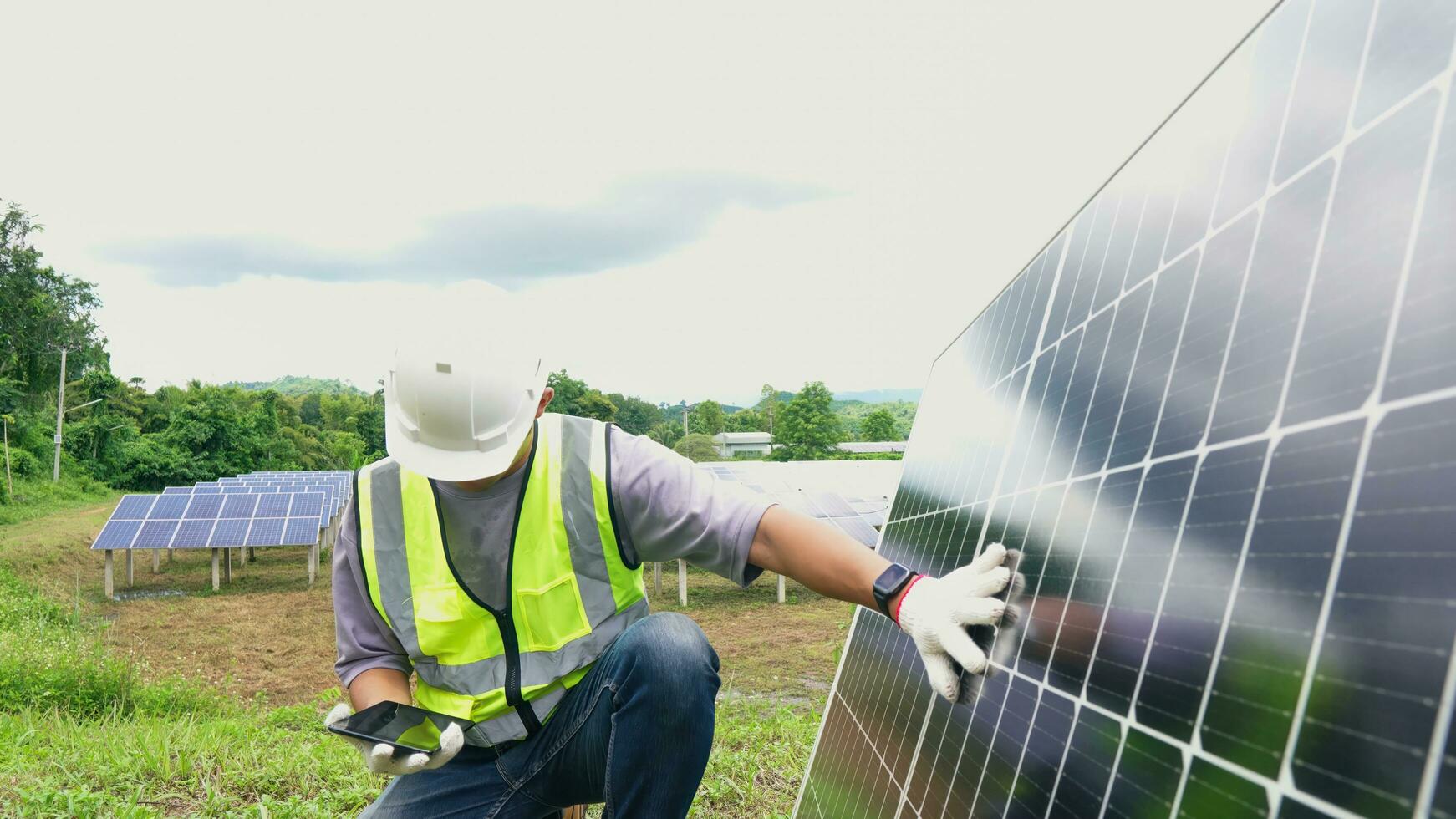 ásia homem engenheiro usando digital tábua mantendo solar célula painéis trabalhando ao ar livre em ecológico solar Fazenda construção. foto