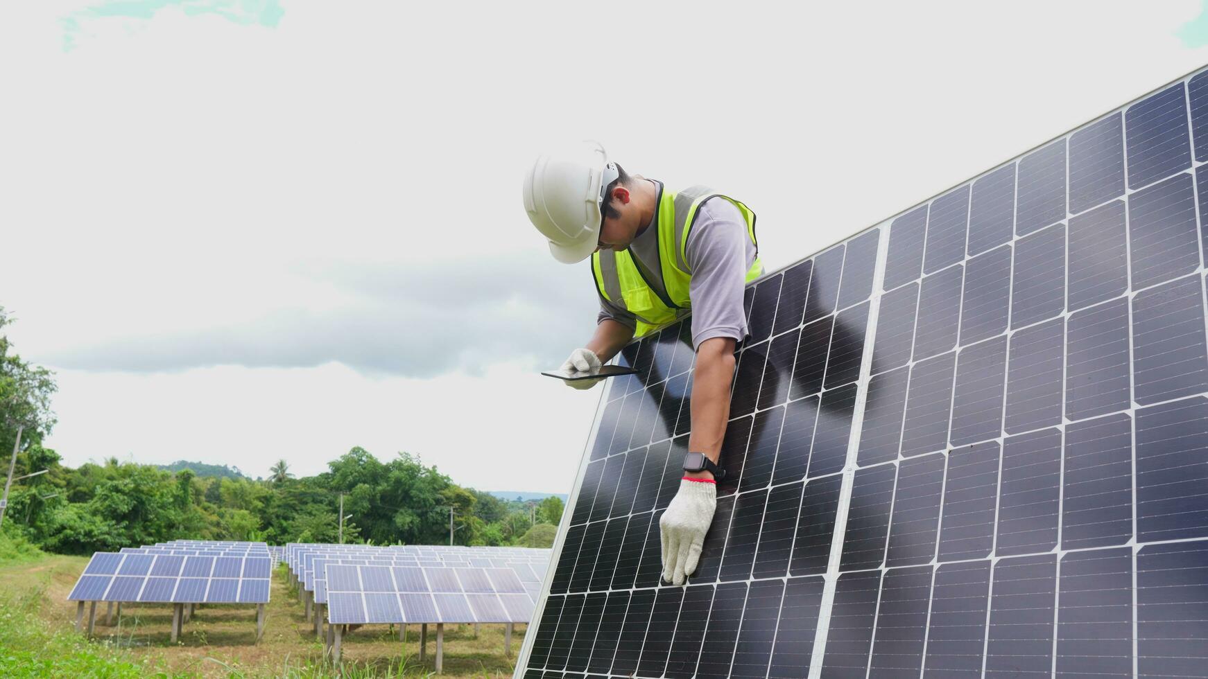 ásia homem engenheiro usando digital tábua mantendo solar célula painéis trabalhando ao ar livre em ecológico solar Fazenda construção. foto