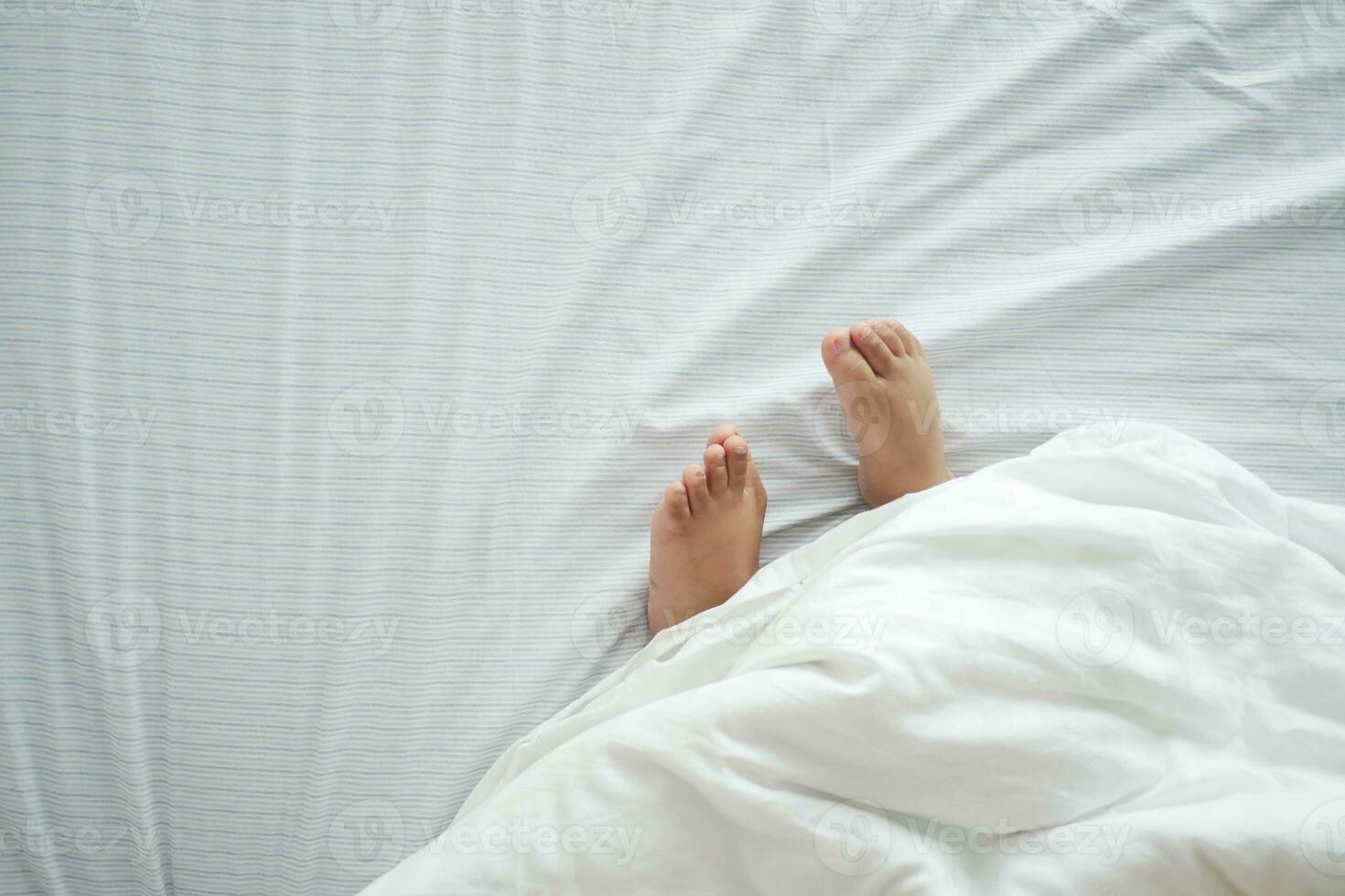 nu pés do uma criança em branco cama foto