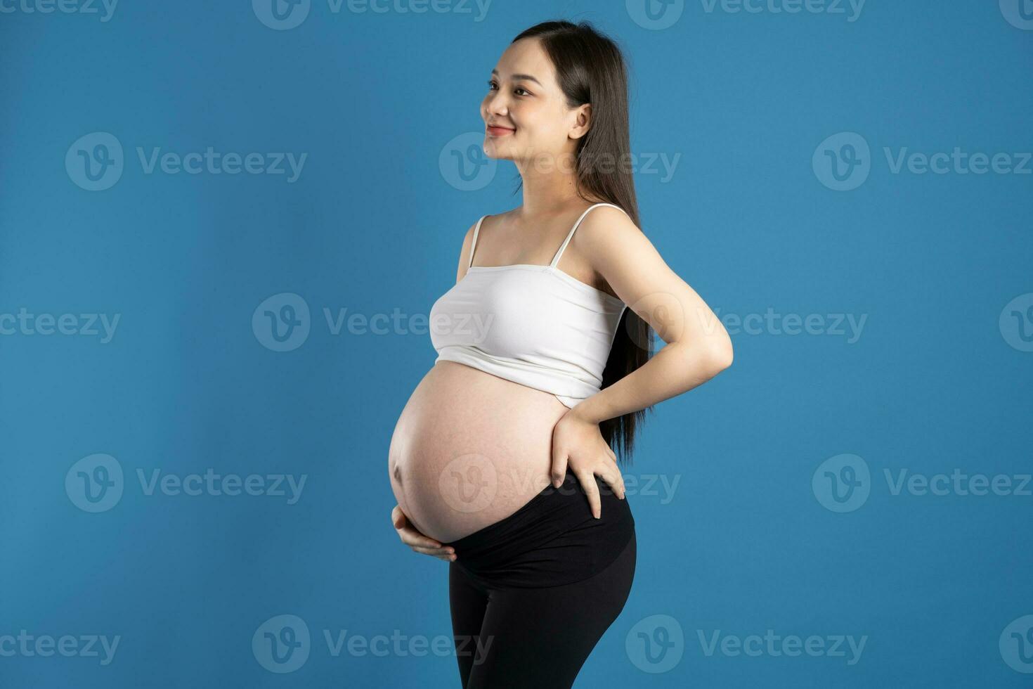 retrato do grávida ásia mulher, isolado em azul fundo foto