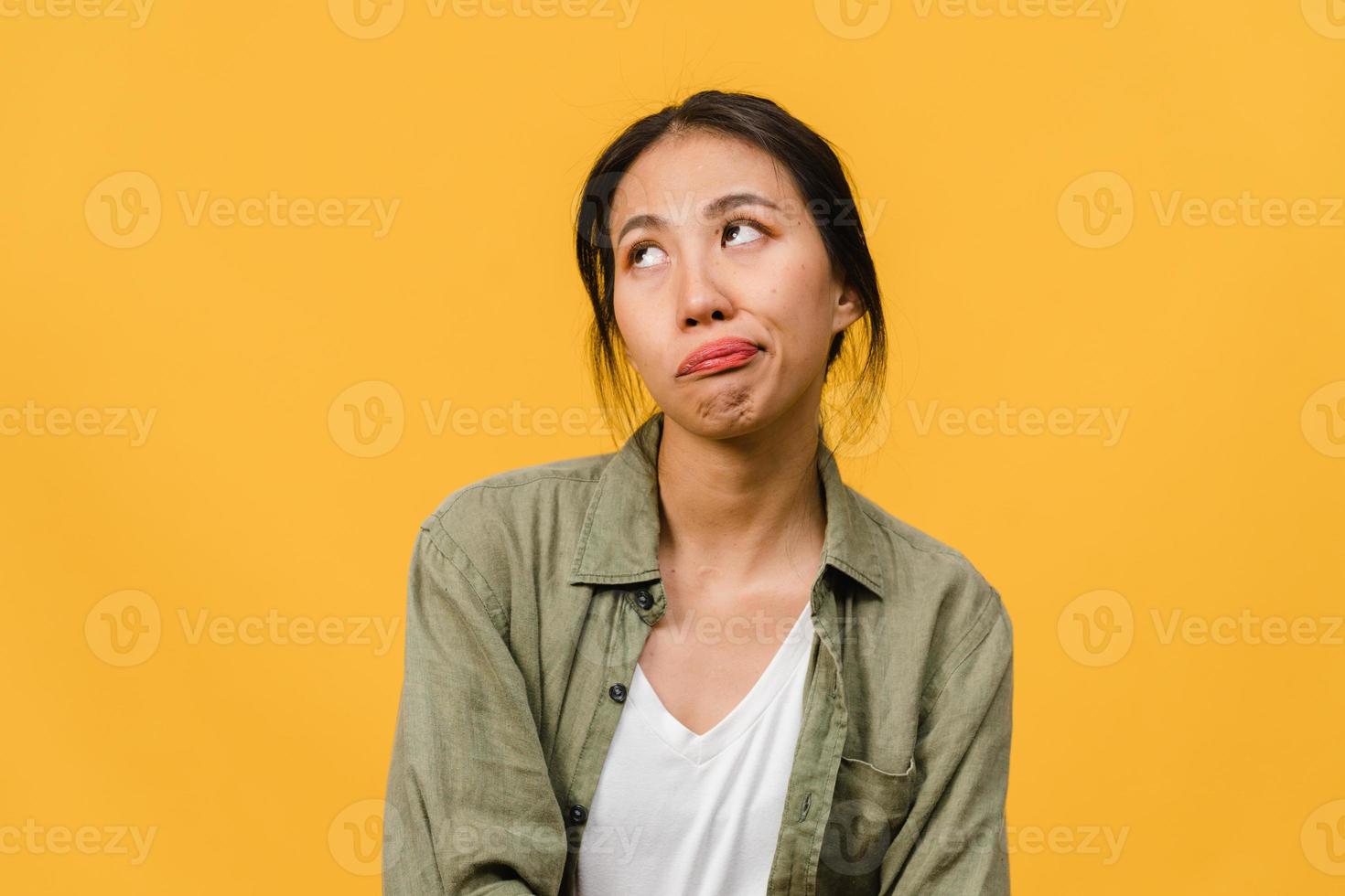 retrato de uma jovem senhora asiática com expressão negativa, animado, gritando, chorando com raiva emocional em roupas casuais, isolado em um fundo amarelo com espaço de cópia em branco. conceito de expressão facial. foto