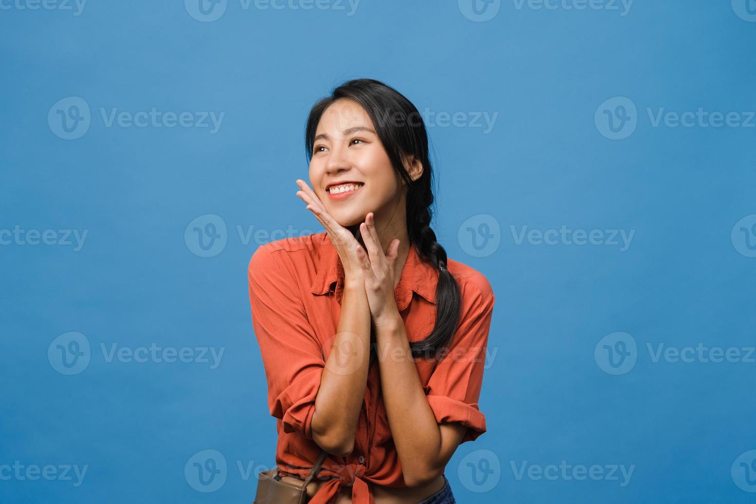 retrato de uma jovem senhora asiática com expressão positiva, sorriso amplo, vestida com roupas casuais sobre fundo azul. feliz adorável feliz mulher alegra sucesso. conceito de expressão facial. foto