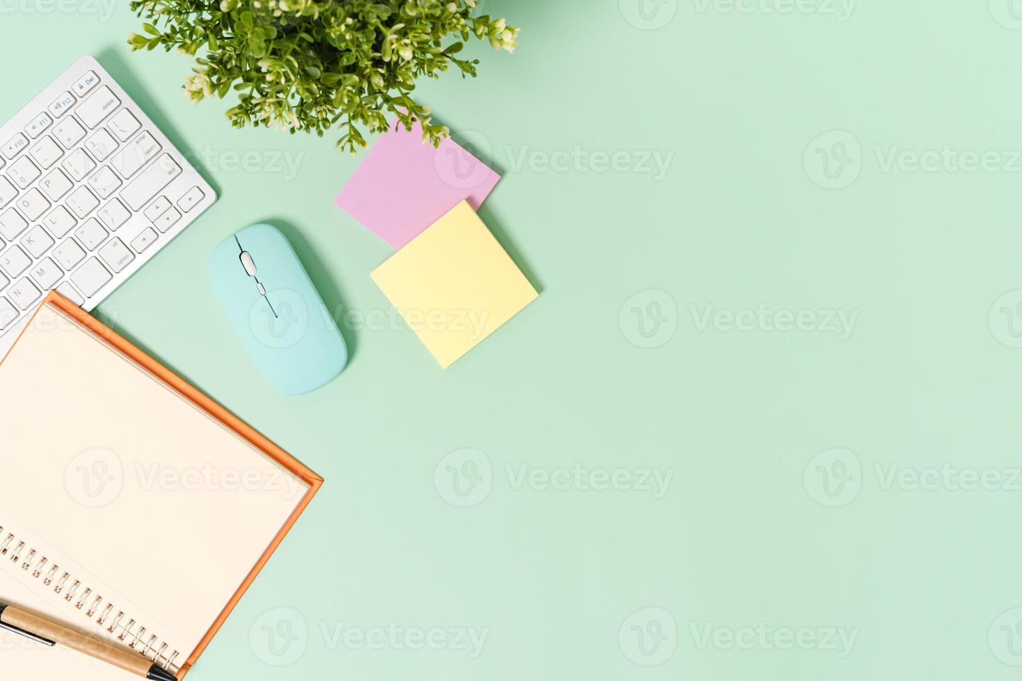 foto plana leiga criativa da mesa do espaço de trabalho. mesa de escritório de vista superior com teclado, mouse e caderno preto de maquete aberta sobre fundo de cor verde pastel. vista superior simulada com fotografia do espaço da cópia.