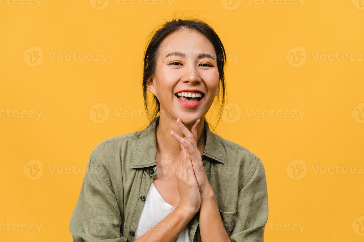 jovem asiática com expressão positiva, sorriso largo, vestida com roupas casuais e olhando para a câmera sobre fundo amarelo. feliz adorável feliz mulher alegra sucesso. conceito de expressão facial. foto