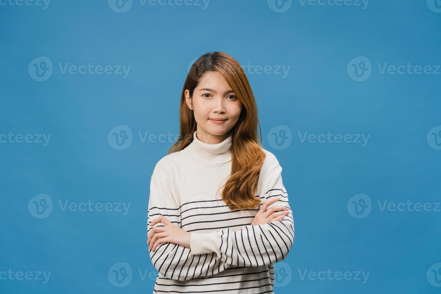 retrato de jovem asiática com expressão positiva, braços cruzados, sorriso largo, vestido com roupas casuais e olhando para a câmera sobre fundo azul. feliz adorável feliz mulher alegra sucesso. foto