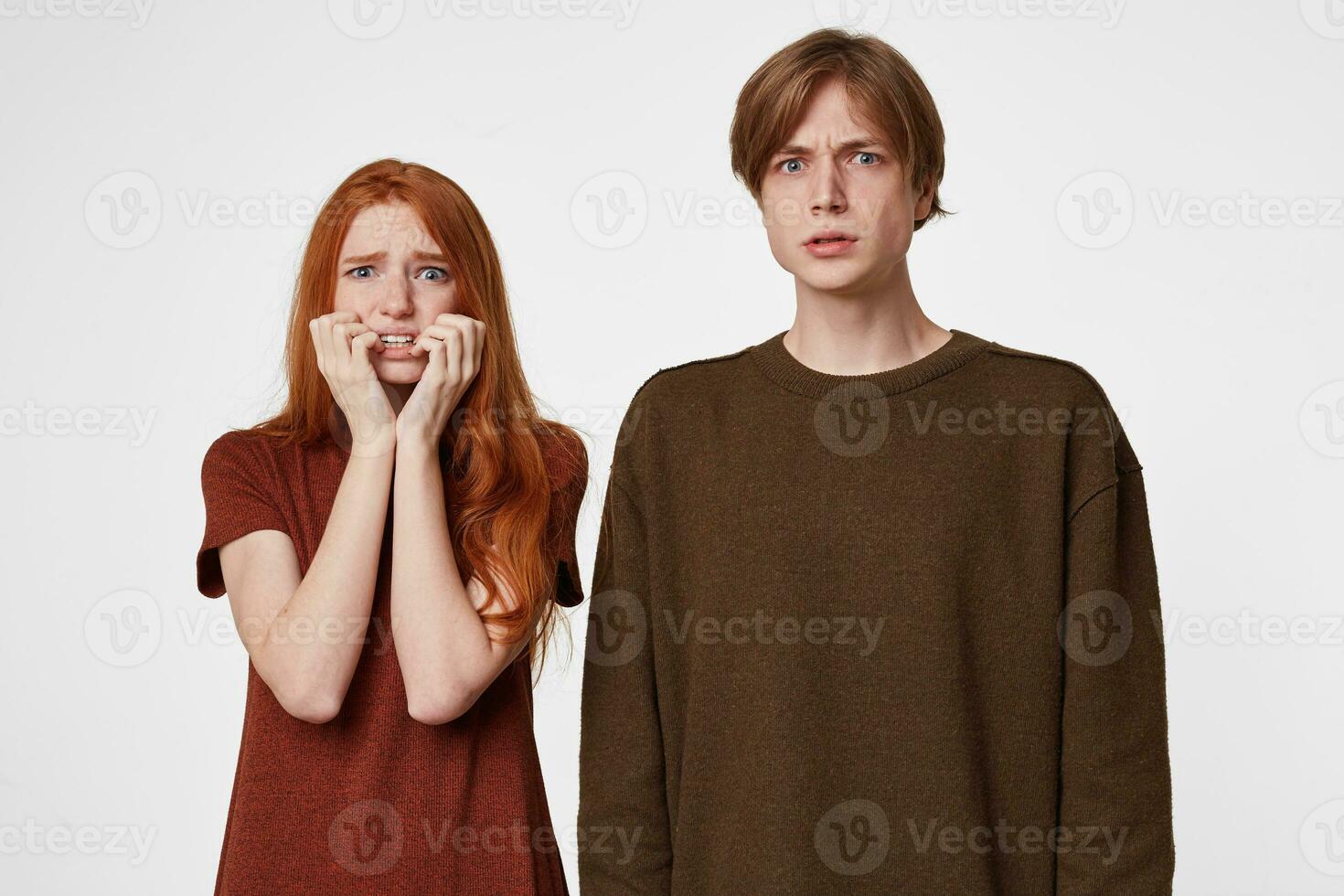 retrato do assustado casal, menina parece assustado receoso tagarelice dentes com medo, mordidas unhas a partir de susto, mãos segurando bochechas, a cara parece tenso sentindo-me ameaçado, sobre branco fundo foto