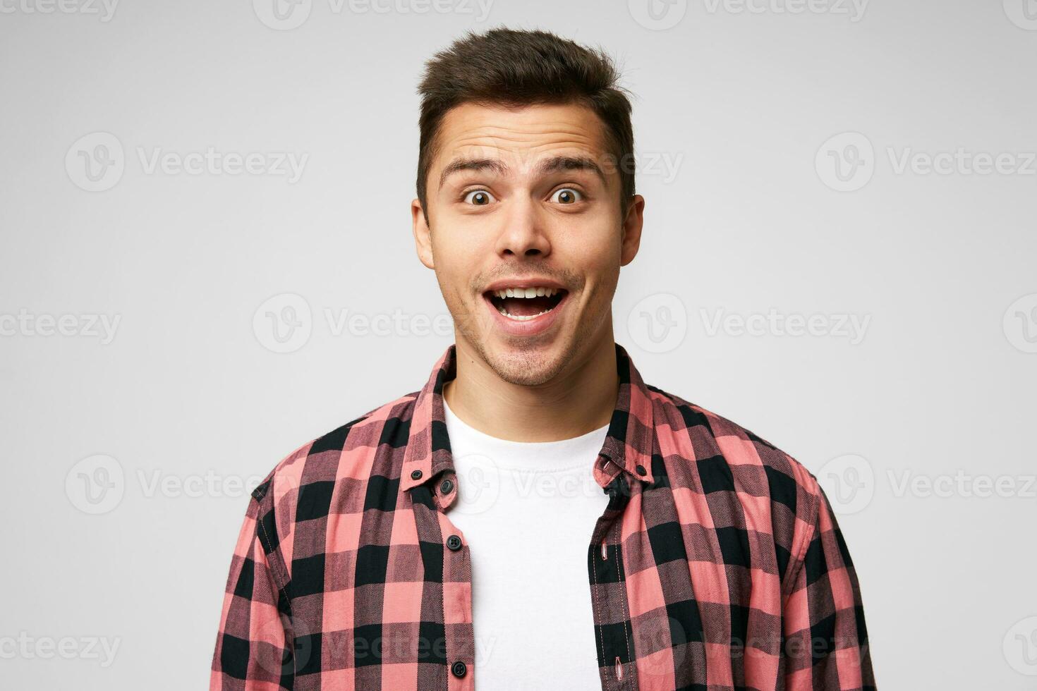 chocado alegre homem, mantém boca abrir, sorrindo, sendo espantado, recebe positivo inesperado notícias, isolado sobre branco fundo. horizontal tiro do jovem masculino retrata surpresa foto