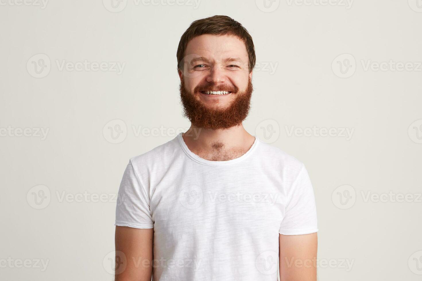 retrato do alegre atraente jovem homem com barba desgasta t camisa foto