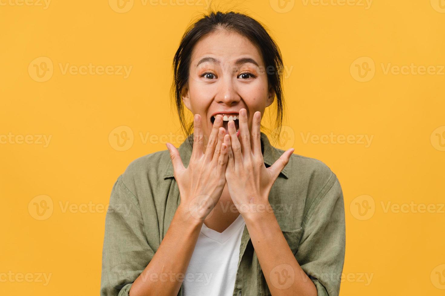 jovem asiática sente felicidade com uma expressão positiva, alegre surpresa funky, vestida com um pano casual e olhando para a câmera isolada em fundo amarelo. feliz adorável feliz mulher alegra sucesso. foto