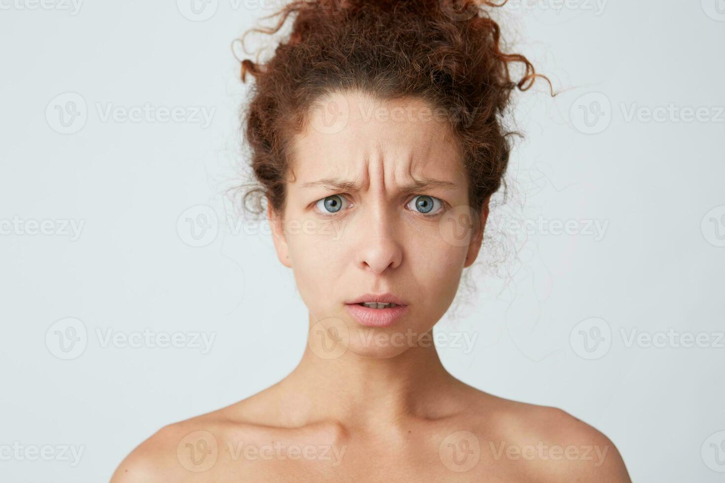 horizontal tiro do triste preocupado jovem mulher com perfeito pele depois de aplicando mascarar ou creme depois de chuveiro sente estressado e ter problemas isolado sobre branco fundo foto