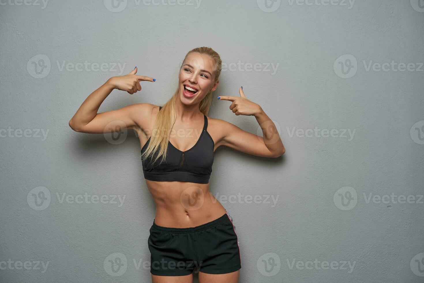 alegre atraente jovem desportivo Loiras mulher com casual Penteado apontando para ela mesma foto