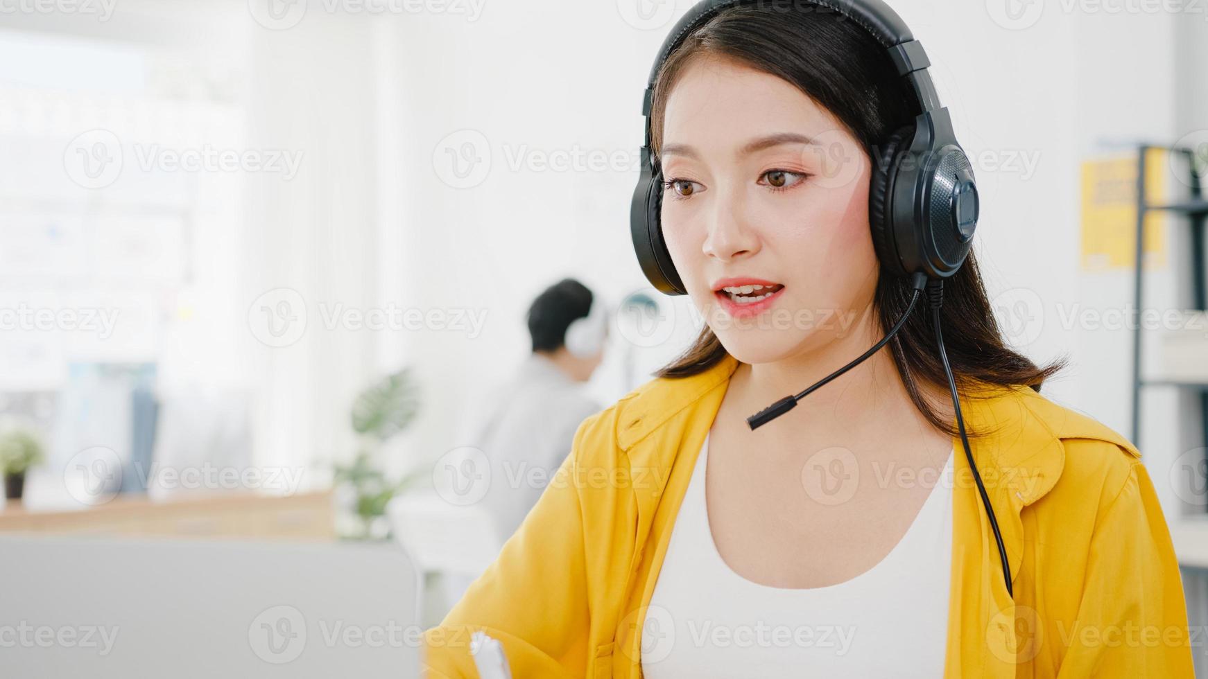 Ásia empresária distanciamento social em nova situação normal para prevenção de vírus ao usar laptop apresentação para colegas sobre plano em videochamada enquanto trabalha no escritório. vida após o vírus corona. foto