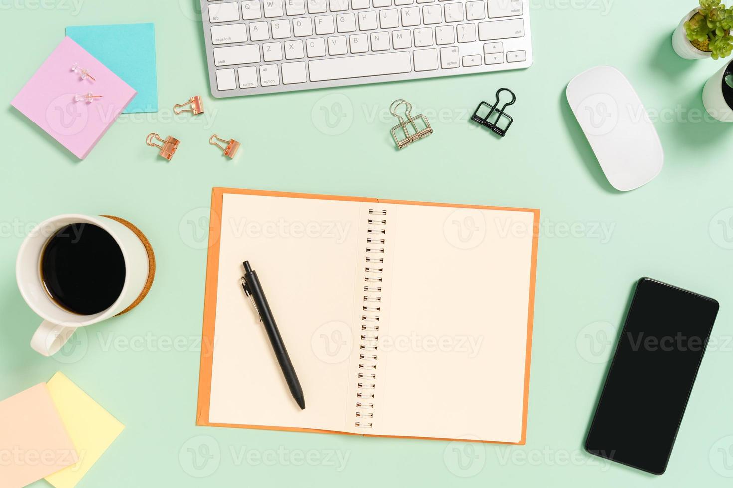 foto plana leiga criativa da mesa do espaço de trabalho. mesa de escritório de vista superior com teclado, mouse e caderno preto de maquete aberta sobre fundo de cor verde pastel. vista superior simulada com fotografia do espaço da cópia.