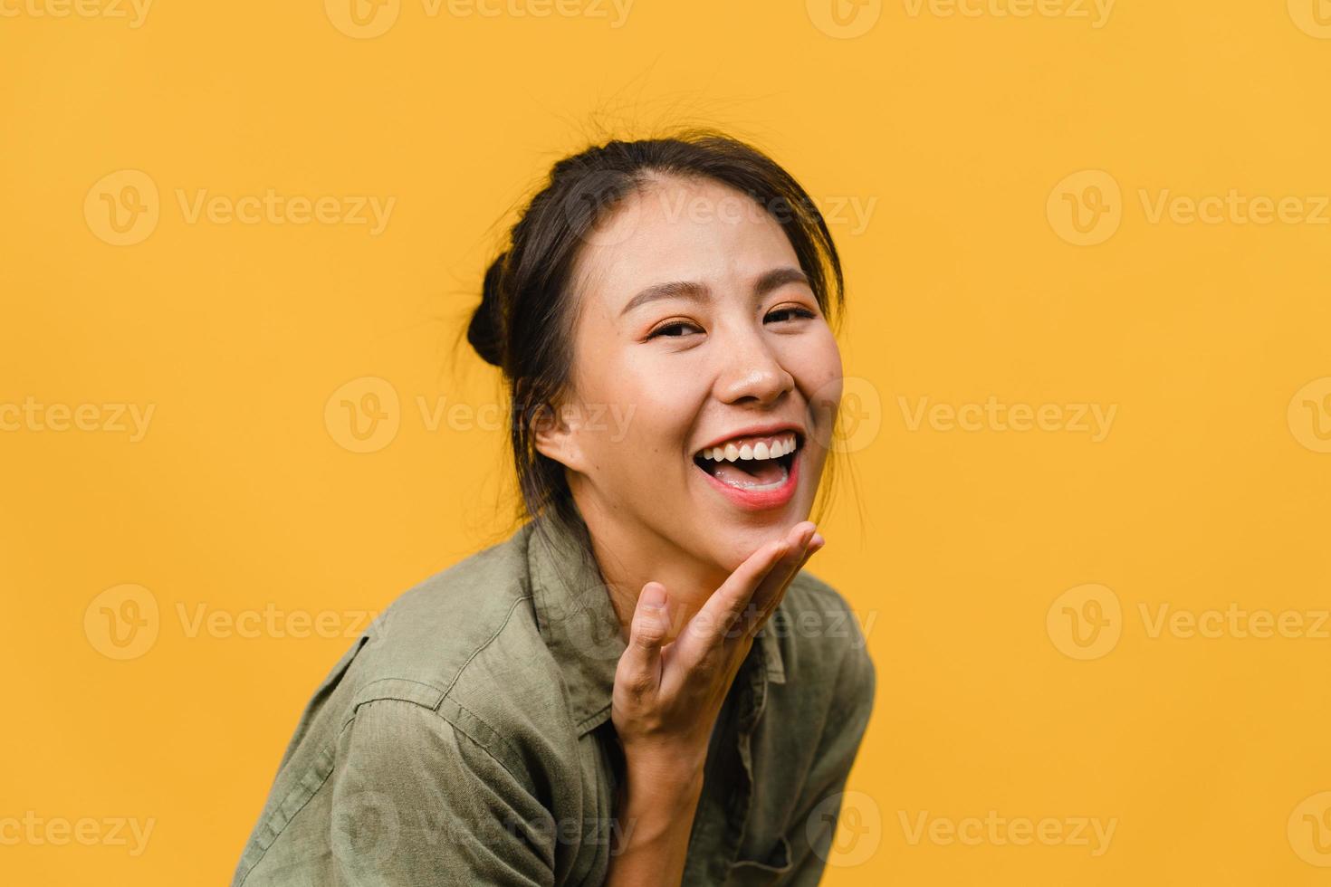 jovem asiática com expressão positiva, sorriso largo, vestida com roupas casuais e olhando para a câmera sobre fundo amarelo. feliz adorável feliz mulher alegra sucesso. conceito de expressão facial. foto