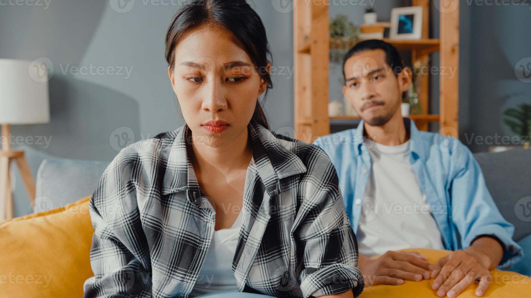 esposa de casal asiático chateado sentar no sofá ouvir marido furioso gritando, sentir infeliz conversa negativa com ela. casal tem briga ou desentendimento em casa, problema de casal, relacionamento tóxico com família e casamento. foto