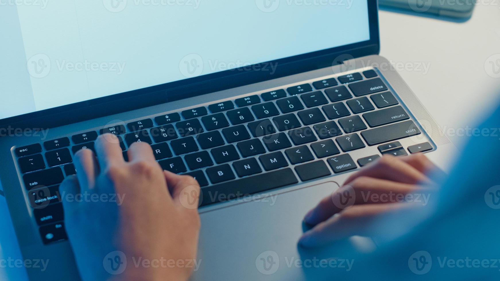 senhora freelance asia usando laptop trabalho duro na sala de estar em casa. trabalhar em casa sobrecarga à noite, trabalhar remotamente, auto-isolamento, distanciamento social, quarentena para prevenção do vírus corona. foto