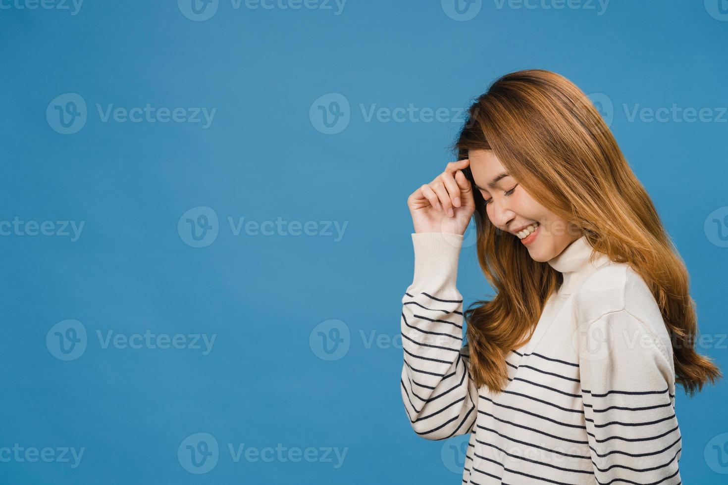 retrato de uma jovem senhora asiática com expressão positiva, sorriso amplo, vestida com roupas casuais sobre fundo azul. feliz adorável feliz mulher alegra sucesso. conceito de expressão facial. foto