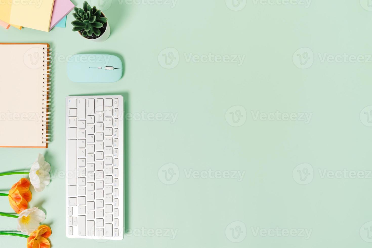 foto plana leiga criativa da mesa do espaço de trabalho. mesa de escritório de vista superior com teclado, mouse e caderno preto de maquete aberta sobre fundo de cor verde pastel. vista superior simulada com fotografia do espaço da cópia.