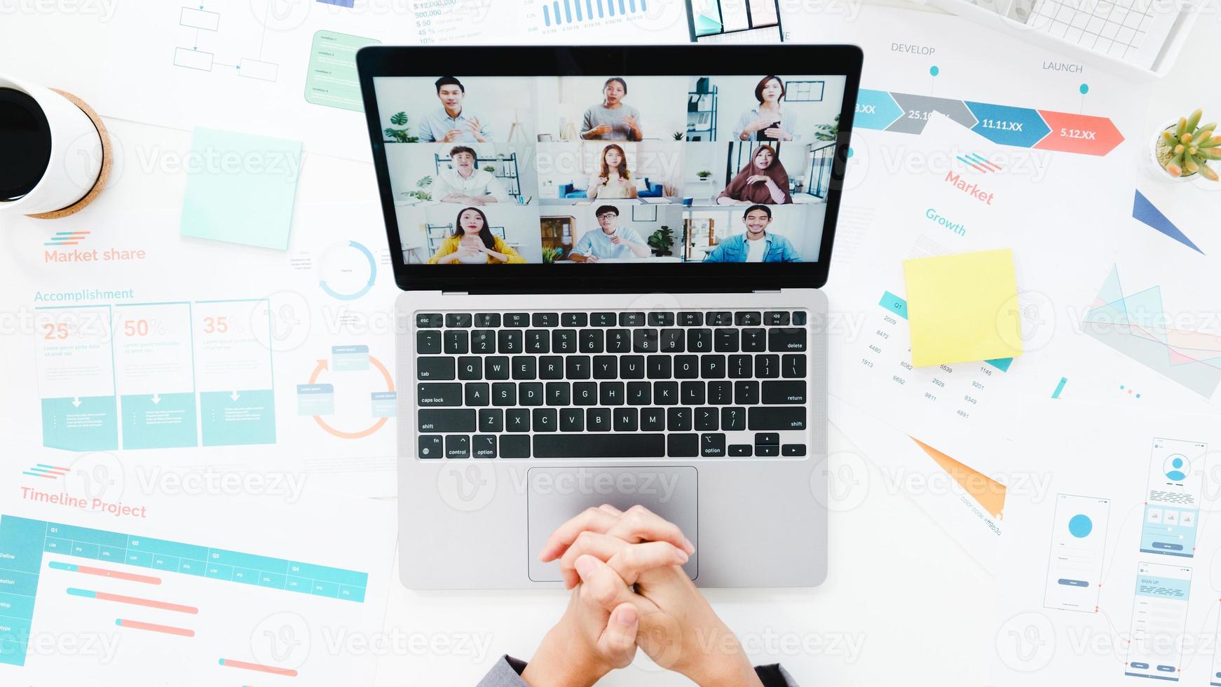 vista superior da jovem empresária asiática usando laptop conversa com um colega sobre o plano de uma reunião de videochamada enquanto trabalha em casa na sala de estar. distanciamento social, quarentena para prevenção do vírus corona. foto