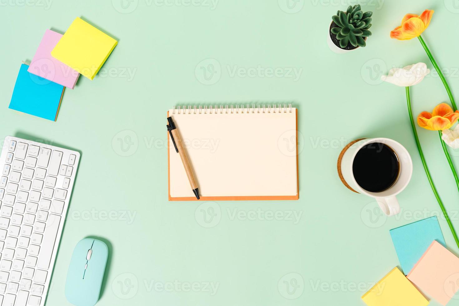 foto plana leiga criativa da mesa do espaço de trabalho. mesa de escritório de vista superior com teclado, mouse e caderno preto de maquete aberta sobre fundo de cor verde pastel. vista superior simulada com fotografia do espaço da cópia.