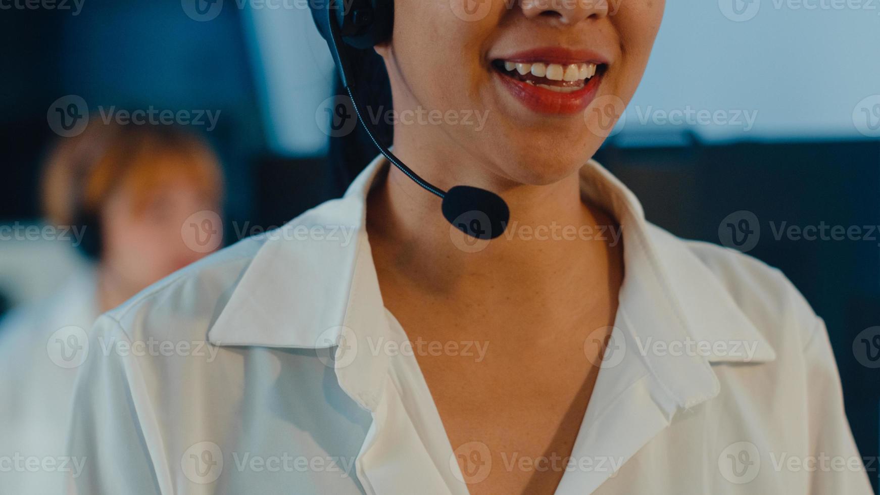 close up da ásia jovem call center equipe ou executivo de serviço de suporte ao cliente usando computador e fone de ouvido microfone trabalhando suporte técnico no escritório tarde da noite. conceito de trabalho de telemarketing ou vendas. foto