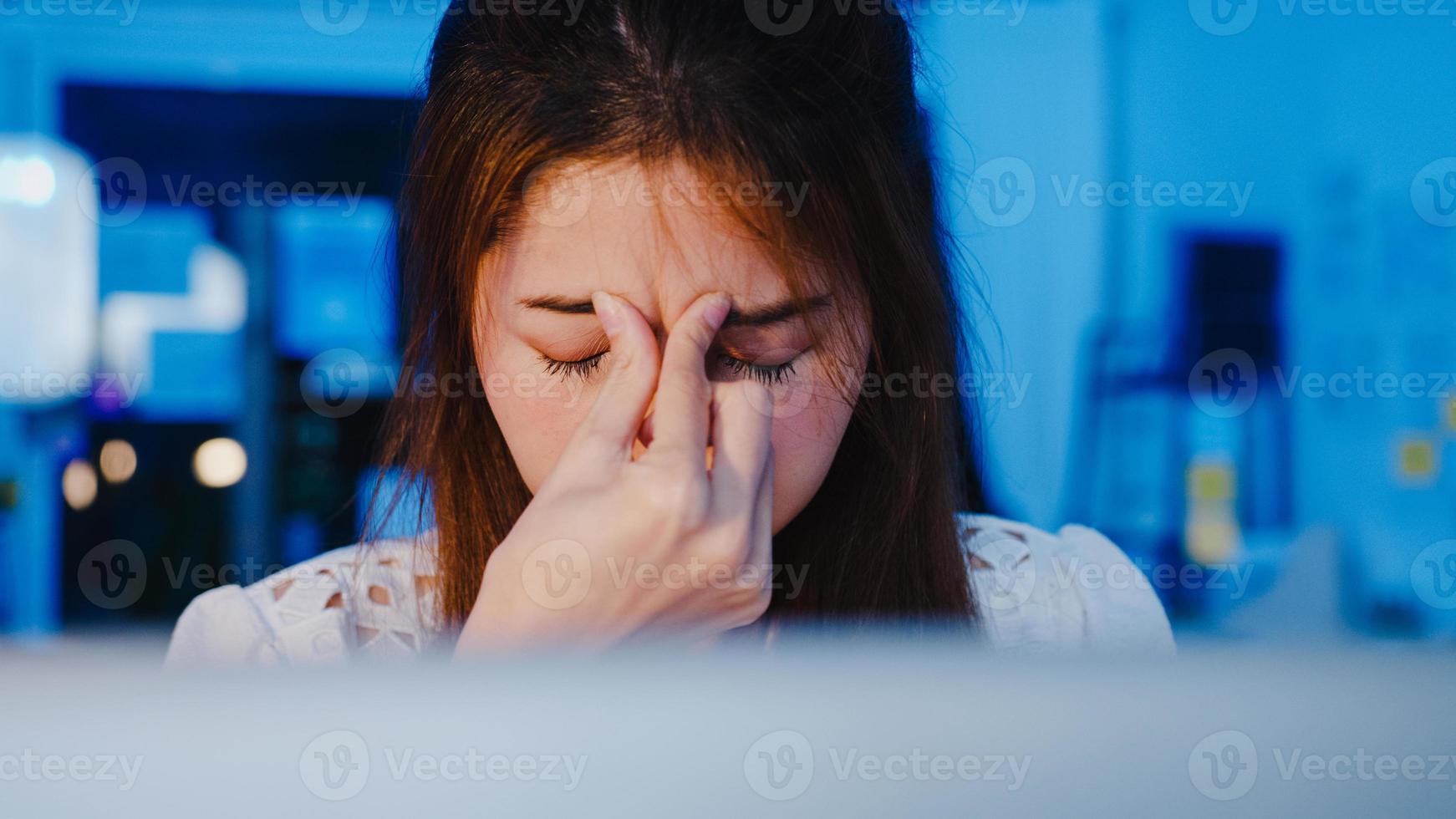 mulheres asiáticas freelance usando laptop trabalham duro no novo escritório doméstico normal. trabalho em casa sobrecarregada à noite, trabalho remoto, auto-isolamento, distanciamento social, quarentena para prevenção do vírus corona. foto