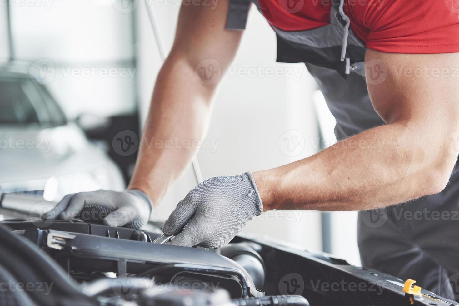 imagem mostrando trabalhador de serviço de carro musculoso consertando veículo foto