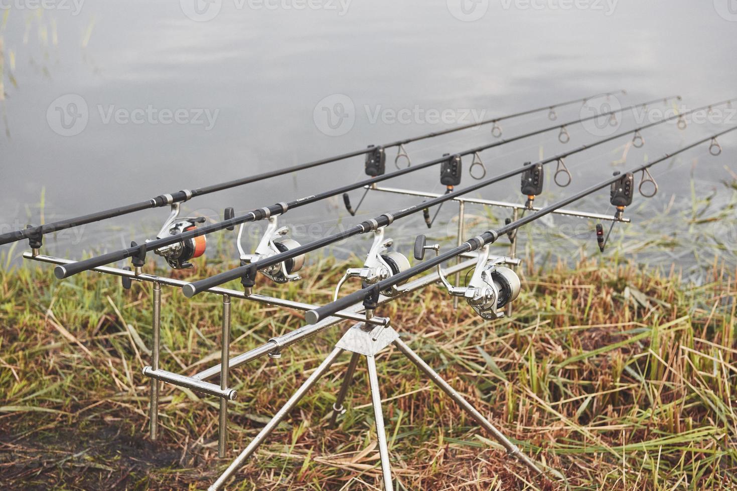 varas de pesca da carpa em tripés especiais. bobinas caras e um sistema de rádio de crochê foto