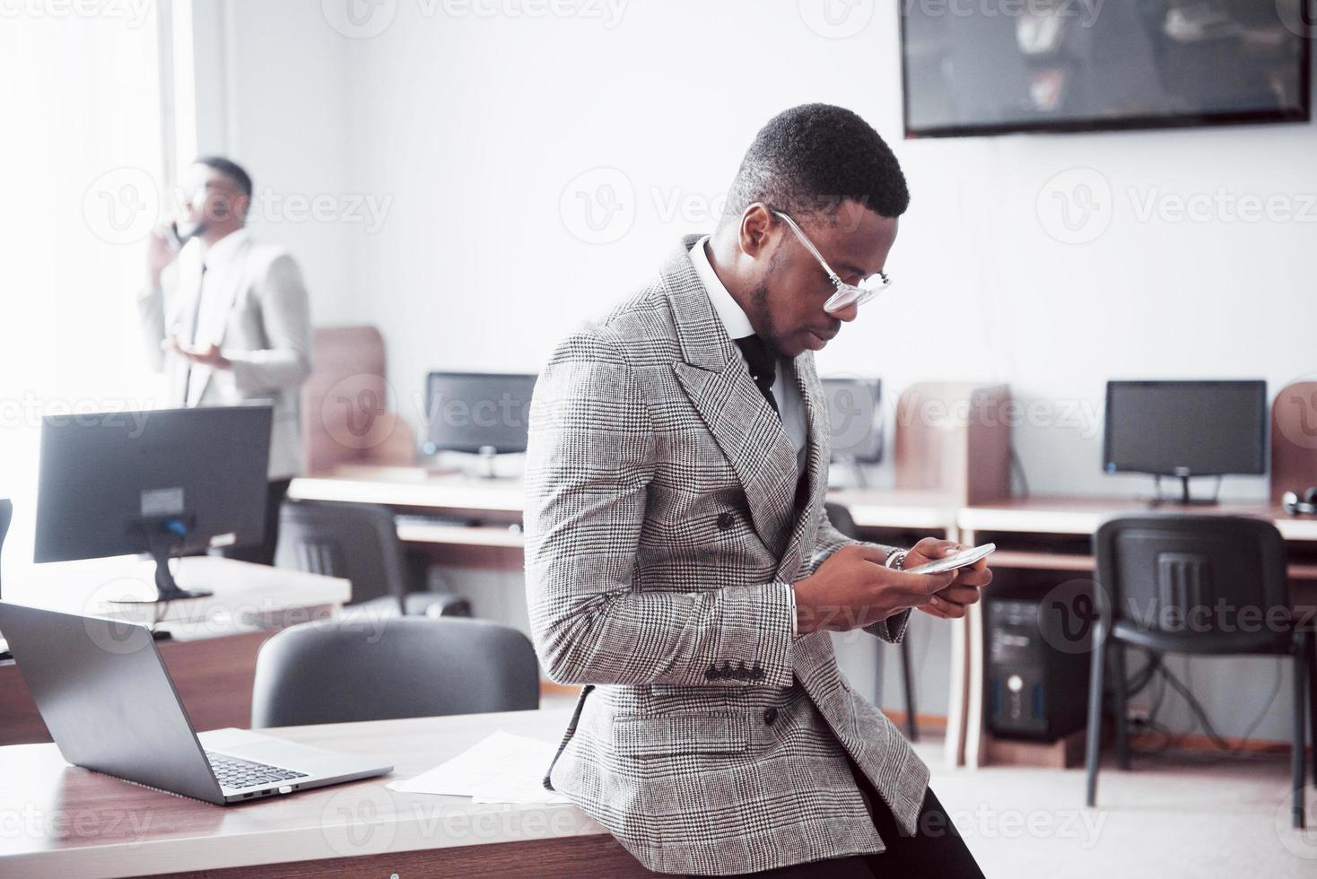 discutir um projeto. dois empresários negros em trajes formais discutindo algo enquanto um deles apontando um papel foto