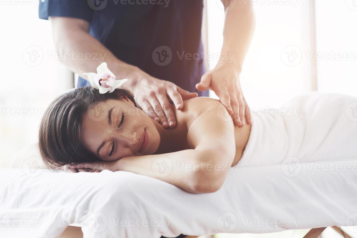 mulher jovem e bonita relaxante com massagem de mãos no spa de beleza. foto