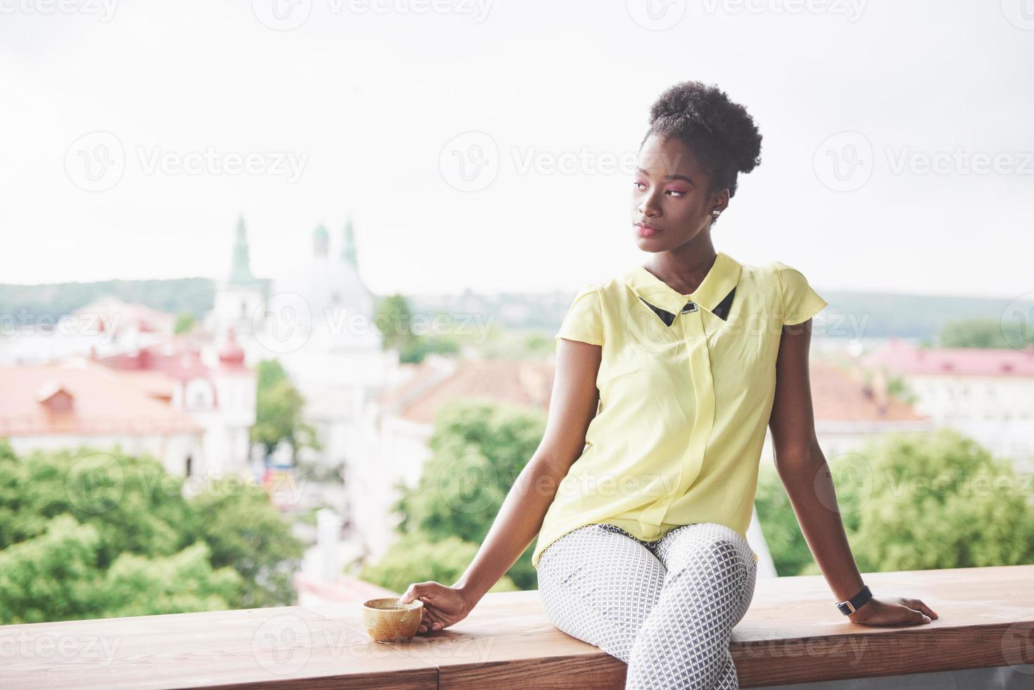 linda jovem mulher de negócios afro-americana tomando café em um café foto