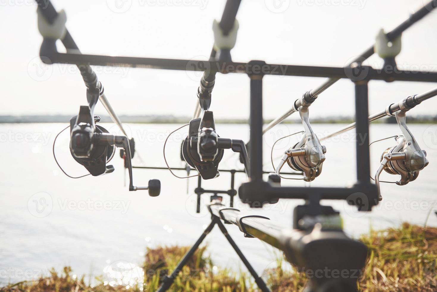 varas de pesca da carpa em tripés especiais. bobinas caras e um sistema de rádio de crochê foto