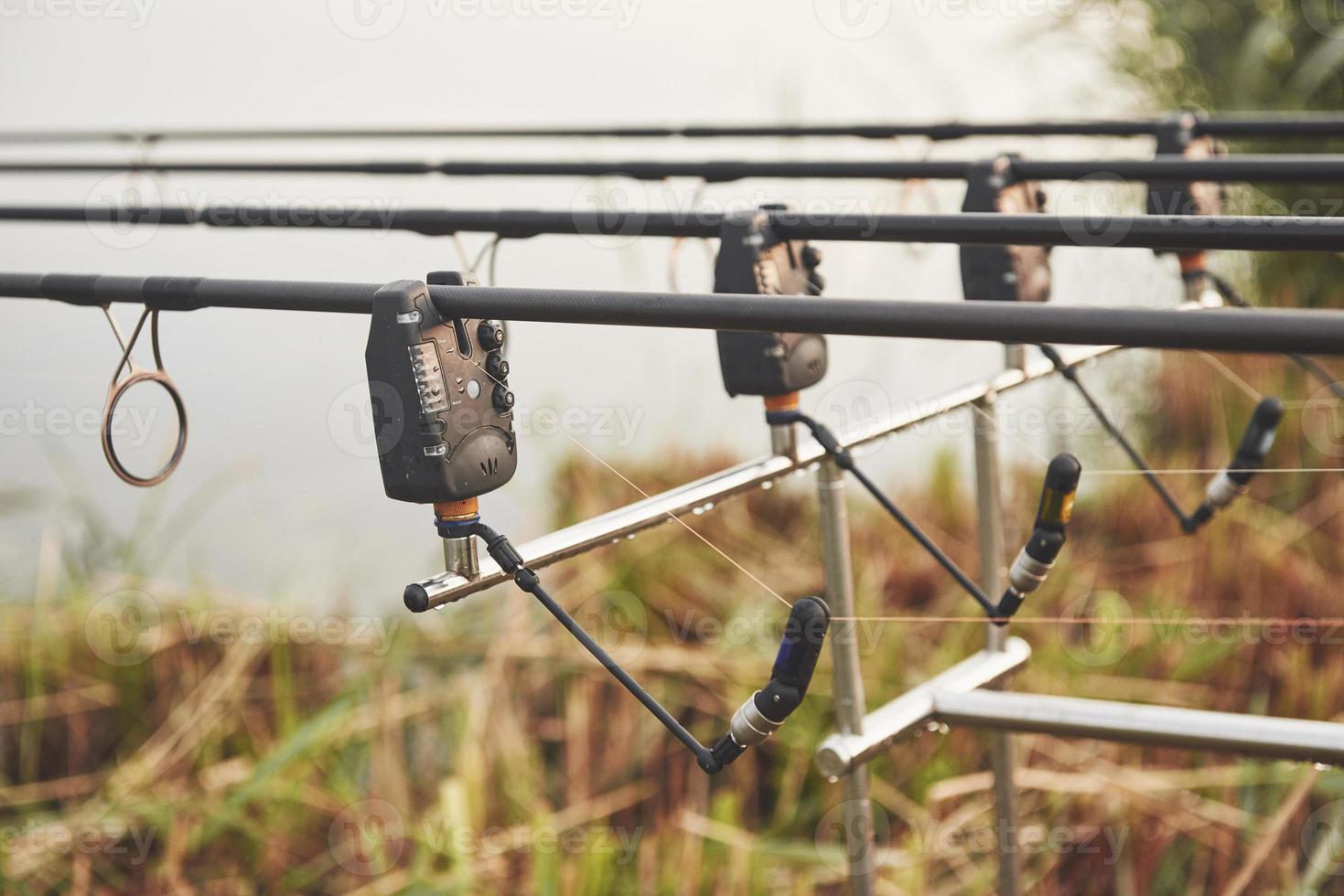 varas de pesca da carpa em tripés especiais. bobinas caras e um sistema de rádio de crochê foto