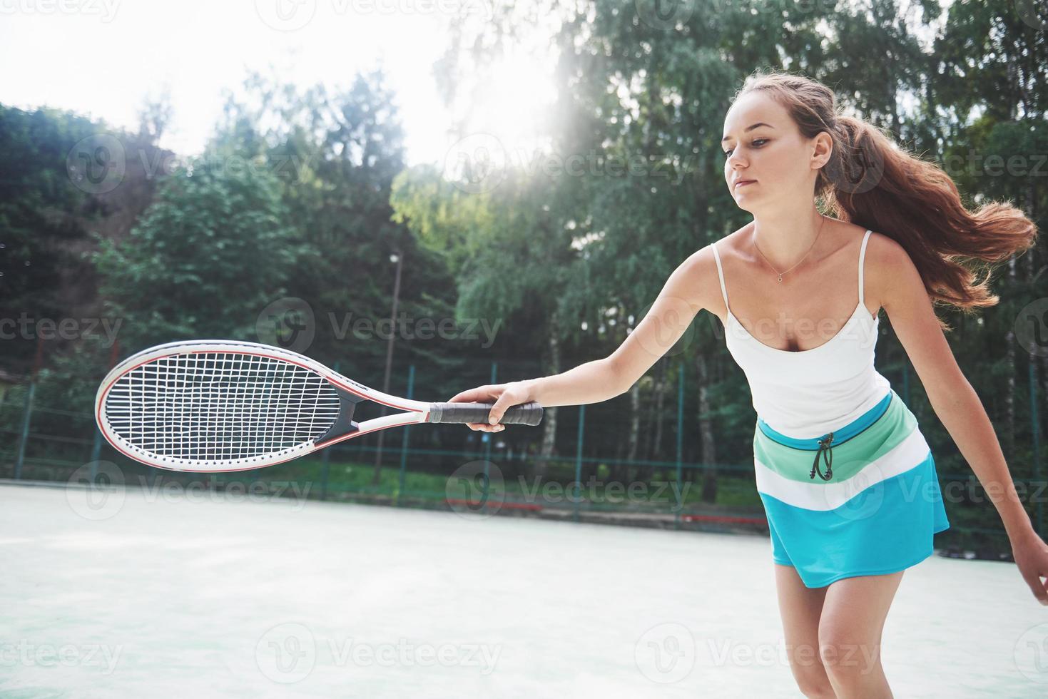 mulher em roupas esportivas serve bola de tênis. foto