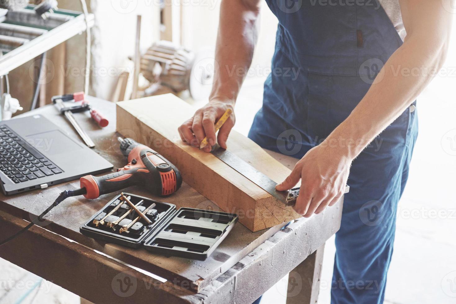 um homem trabalha em uma marcenaria, trabalhando com uma árvore. foto