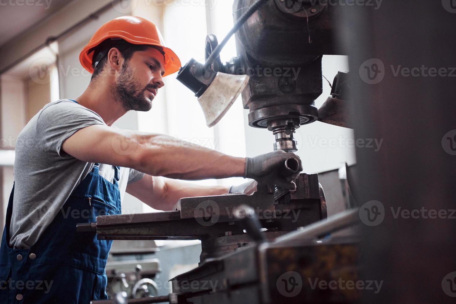 operador experiente em um capacete. conceito da indústria metalúrgica engenheiro profissional metalúrgico operando centro de fresadora cnc na oficina de manufatura foto