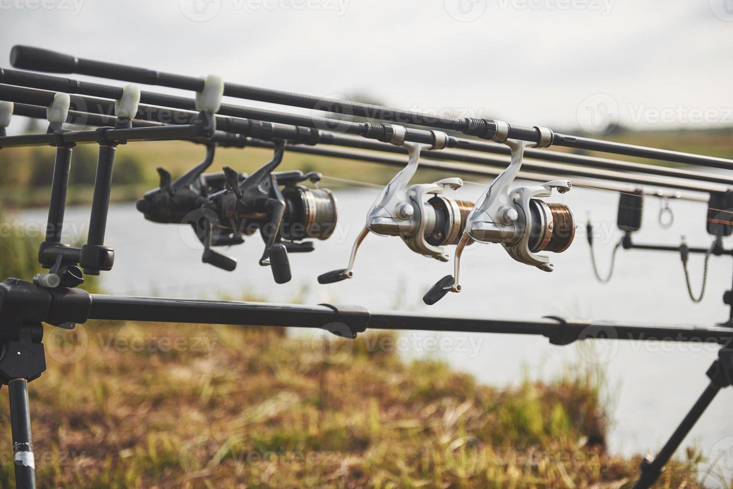 varas de pesca da carpa em tripés especiais. bobinas caras e um sistema de rádio de crochê foto